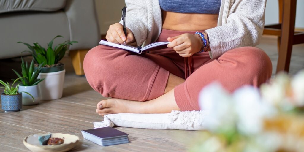 Woman sitting cross-legged on the floor journaling